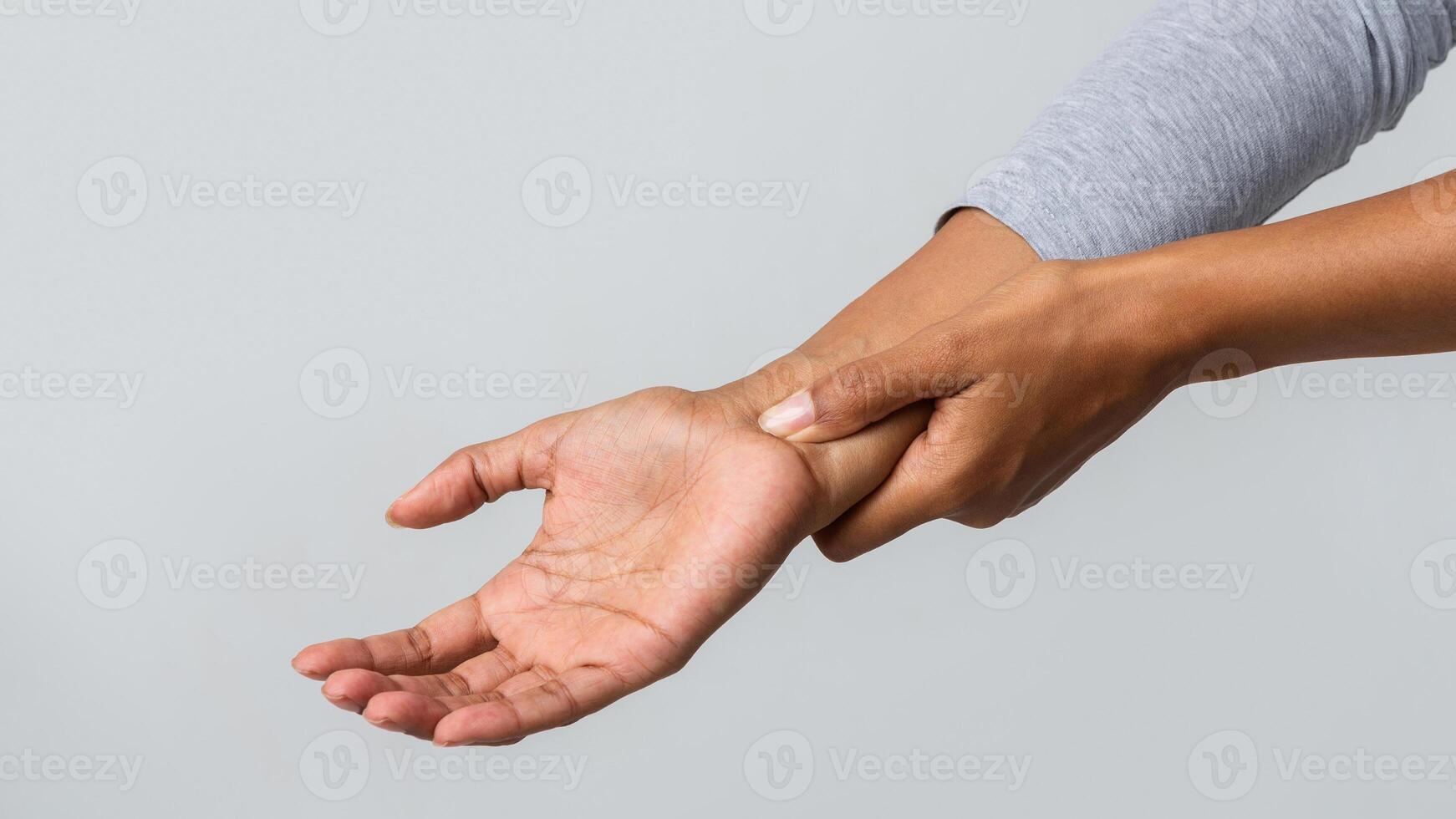 Close up of black woman holding her wrist, having pain from using computer. Office syndrome, joint pain by occupational disease. photo