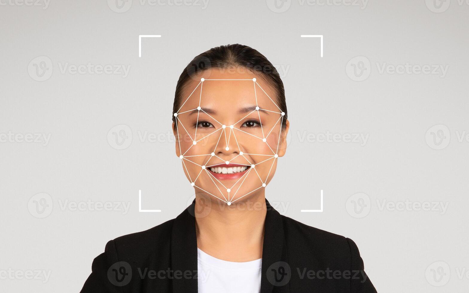 Chinese woman is smiling as facial recognition technology is displayed on her face in a professional studio environment. photo