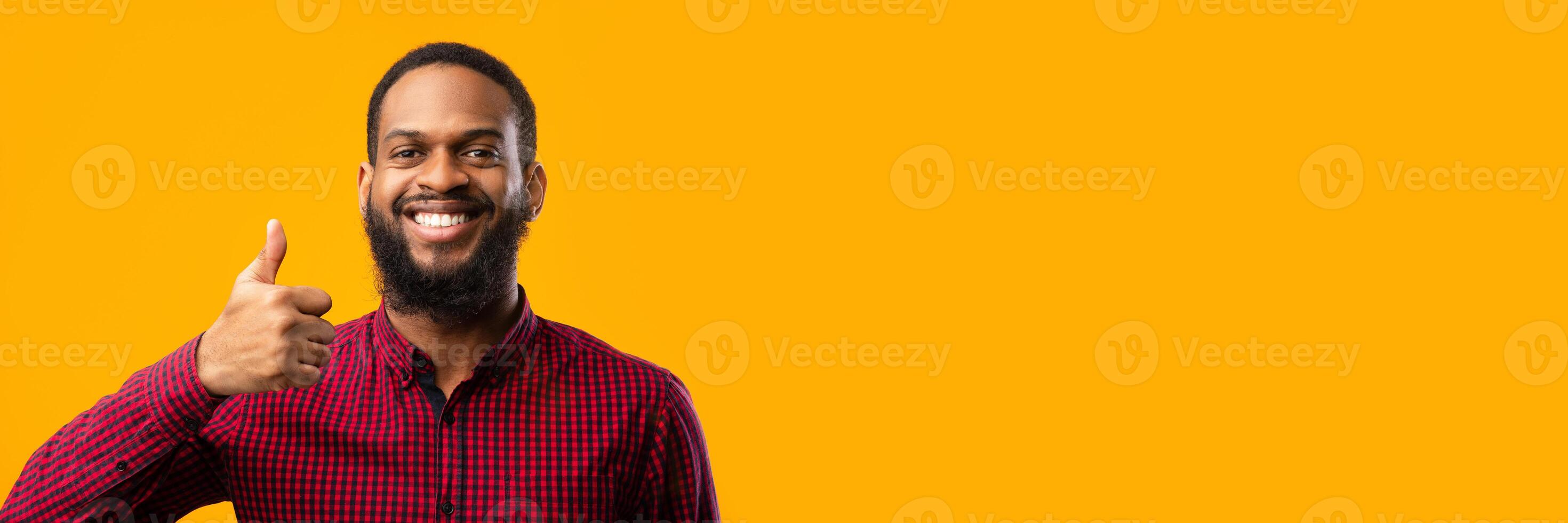 I Like It Concept. Headshot Closeup Portrait Of Smiling African American Guy Gesturing Thumbs Up At Camera. Confident Man Agree, Standing Isolated Over Yellow Background In Studio. Copy Space photo