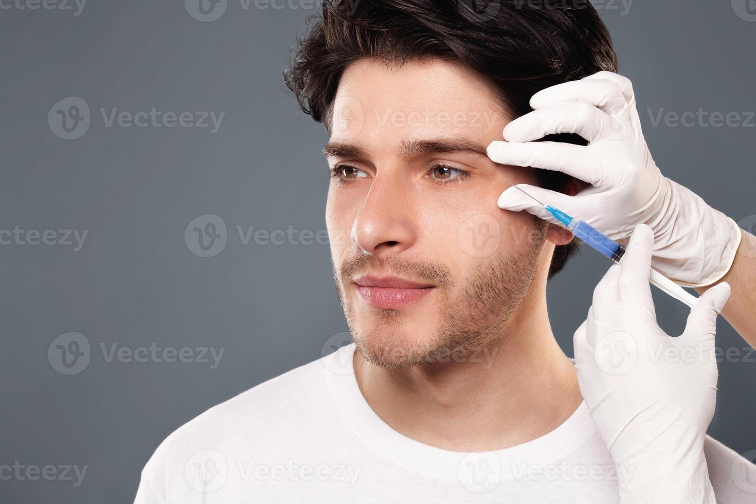 Beauty injection for men. Millennial guy getting surgery filling of facial wrinkles, empty space photo