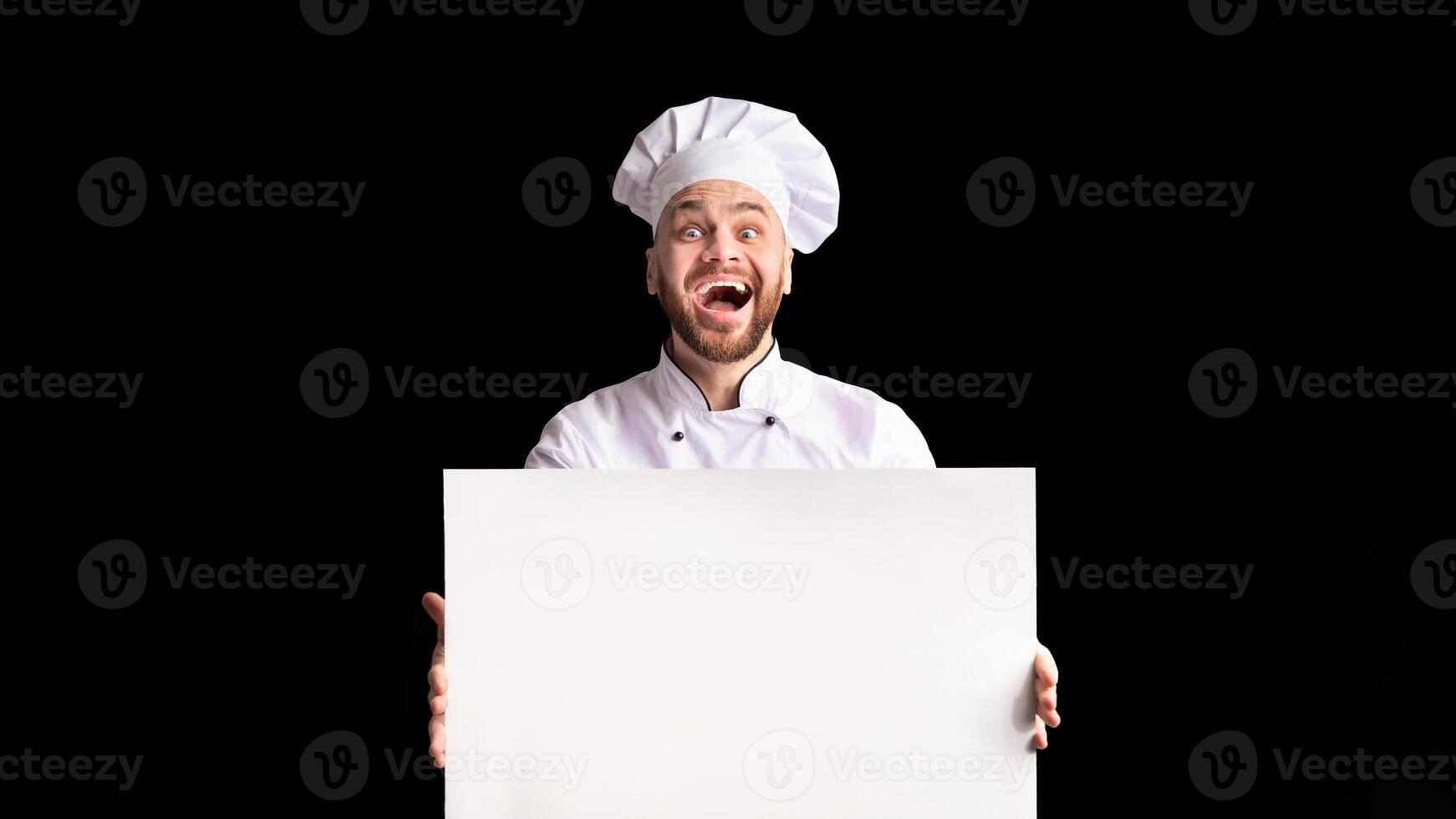 Restaurant Menu. Excited Chef Man Holding Empty White Board For Text Advertising Something Standing Over Black Background In Studio. Mockup photo