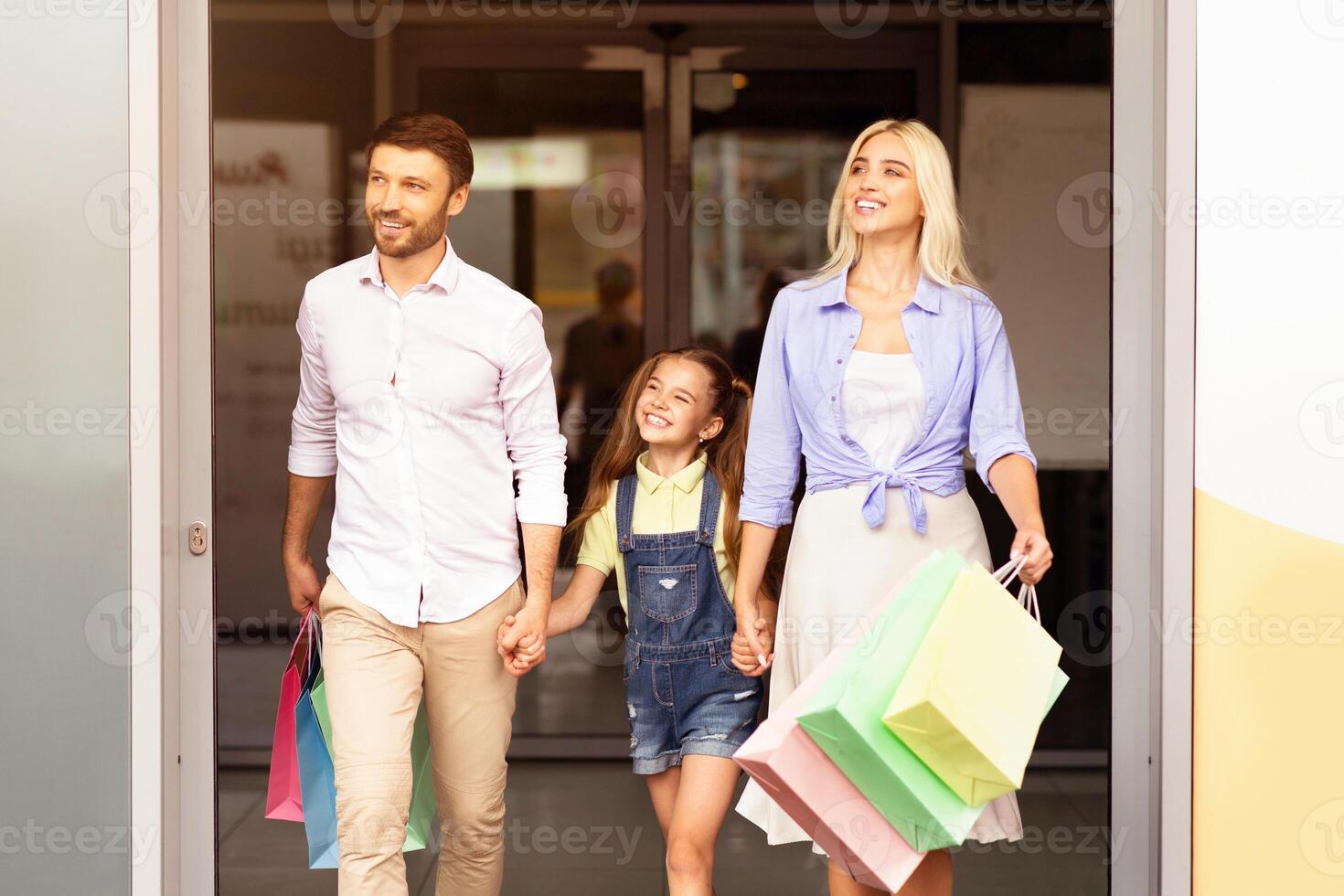 Seasonal Sales And Shopping. Happy European Family Leaving Mall Center Carrying Shopper Bags. Free Space photo