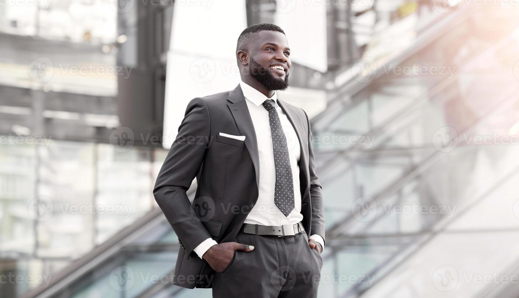 Successful Business. Confident African Businessman Standing Holding Hands In Pockets In Urban Area Outside. Free Space photo