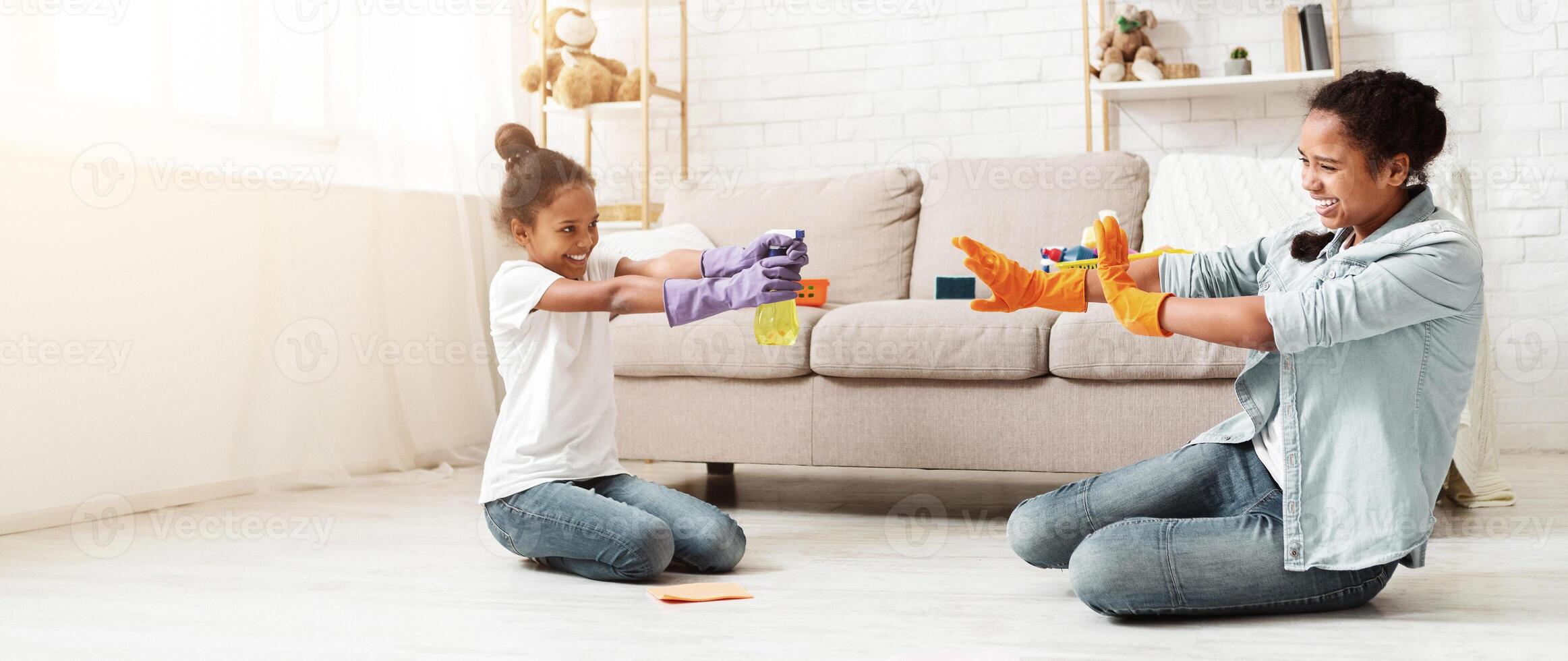 Playful african american girls having fun during cleaning home, panorama with empty space photo
