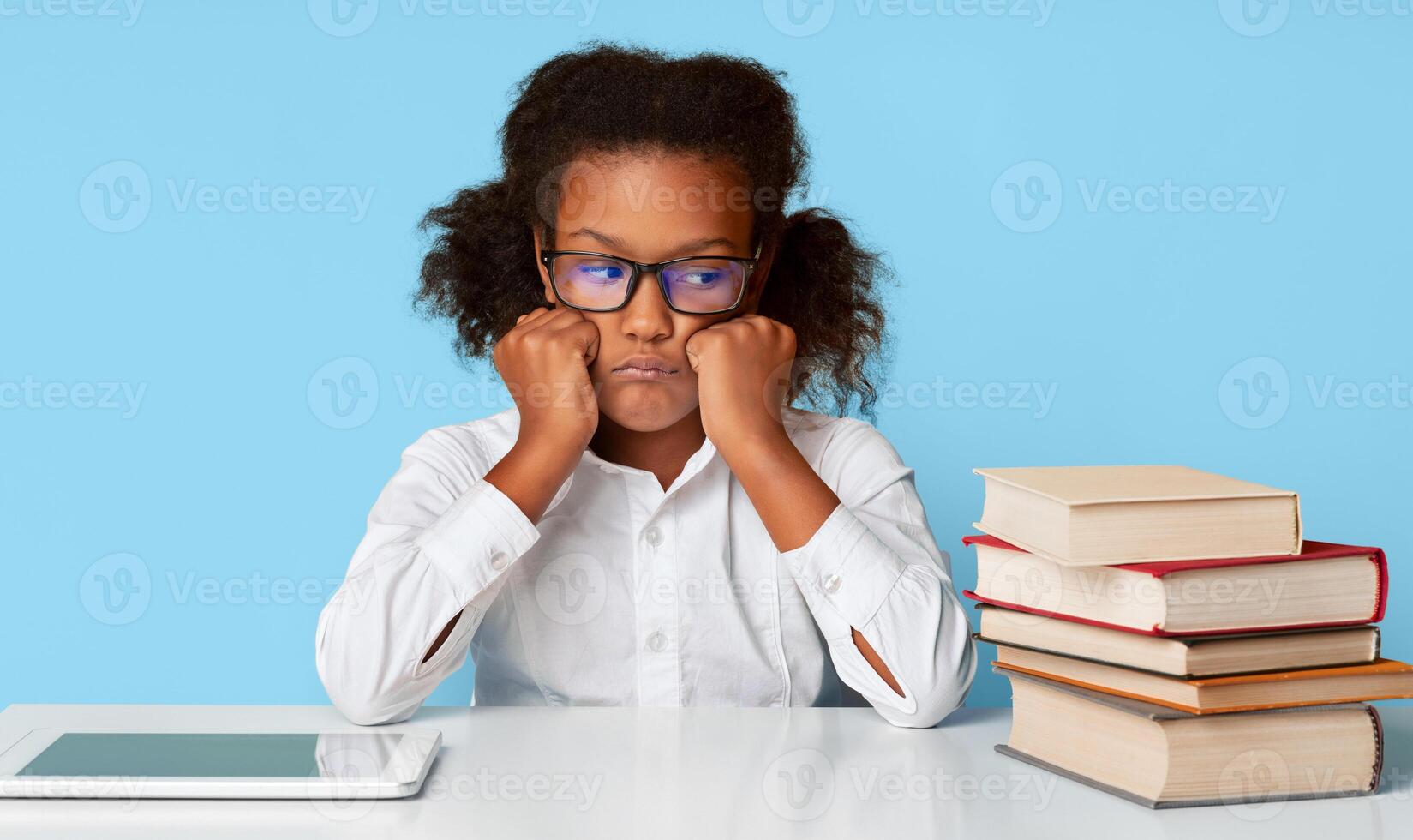 Quarantine E-Learning Problems. Unhappy Schoolgirl Sitting At Digital Tablet And Books Tired Of Learning From Home. Yellow Studio Background photo