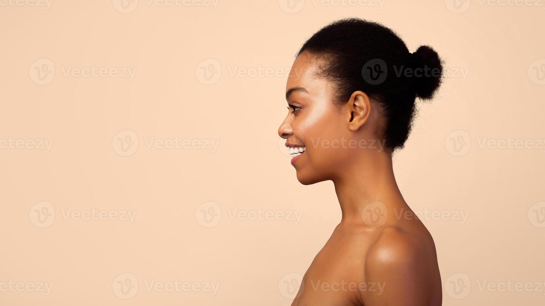 Profile Portrait Of Happy Black Woman Smiling Looking Aside At Empty Space For Text Posing Shirtless Standing On Gray Background. Panorama, Studio Shot. Side View Headshot Of Attractive African Female photo