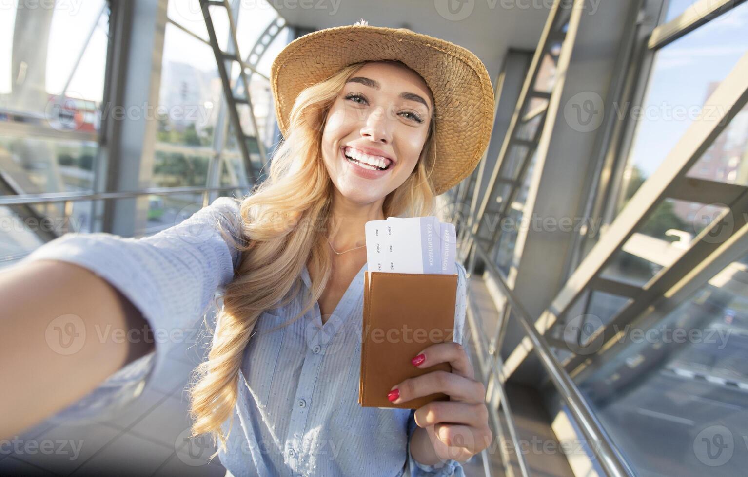 Enjoy traveling. Beautiful woman taking selfie in airport, waiting for boarding photo