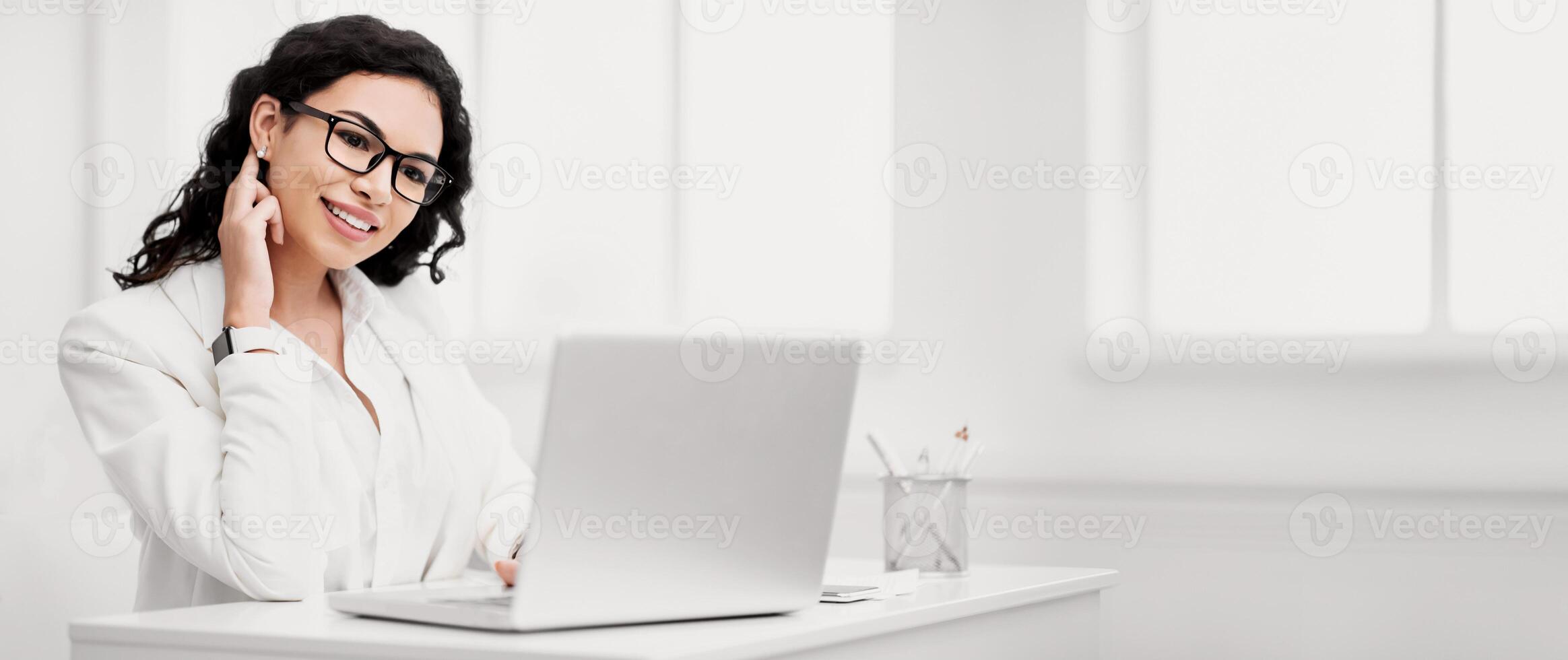Office Work Concept. Smiling mexican businesswoman working on laptop in modern office. Copy space photo