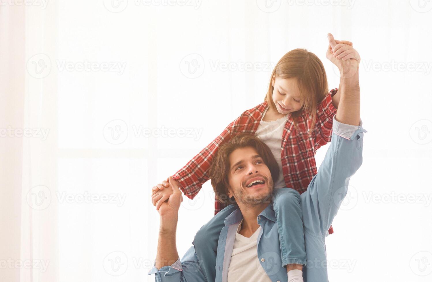 Cheery father and little girl having fun over white background at home, happy family concept, copy space photo