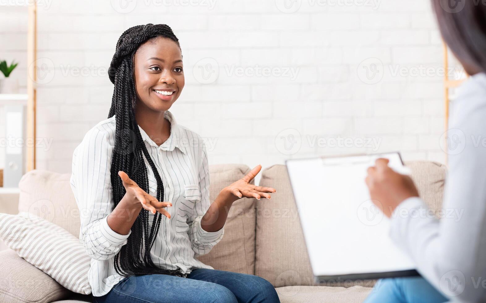 Successful therapy. Happy black female patient talking to psychologist at her office, expressing gratitude photo