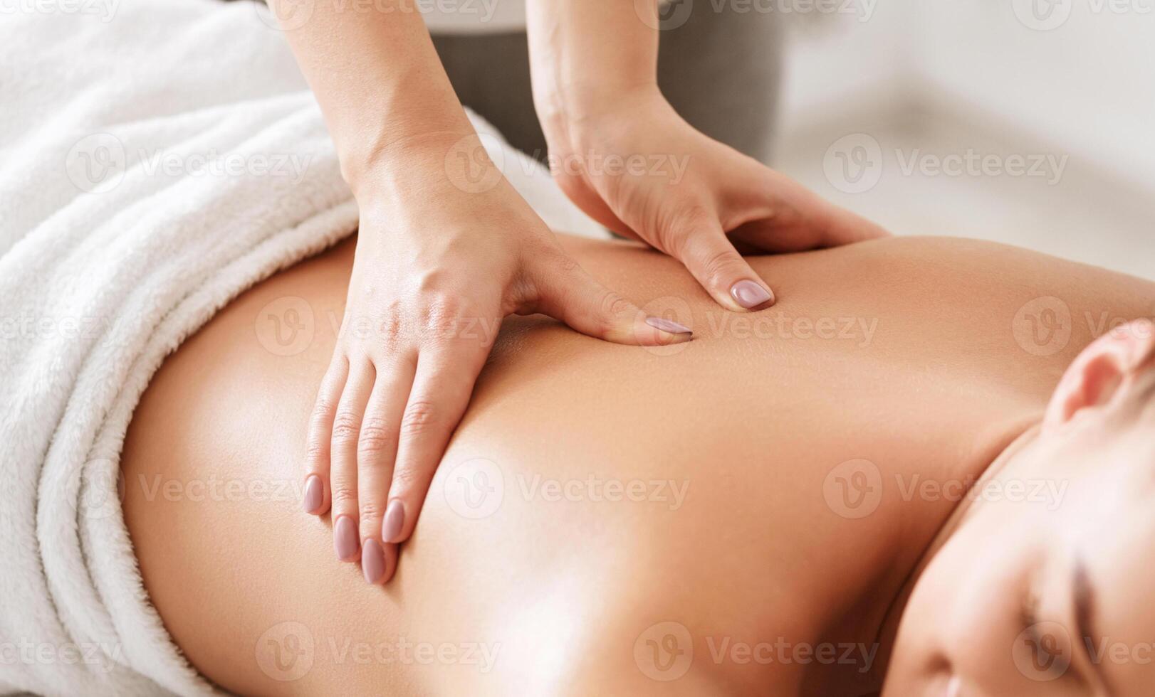 Body care. Young girl having massage, relaxing in spa salon, closeup photo