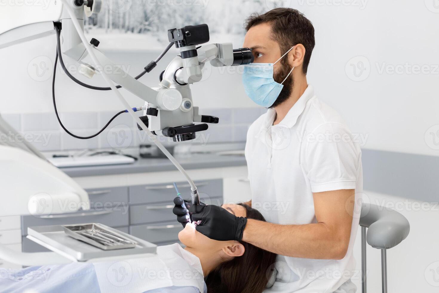 Professional bearded male dentist using modern technologies in dental treatment, complicated cases in stomatology photo