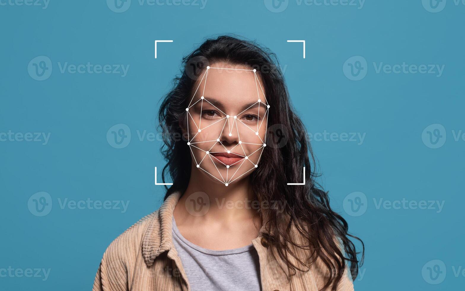 A woman with curly hair stands against a blue background, showcasing facial recognition technology with geometric outlines over her face. photo