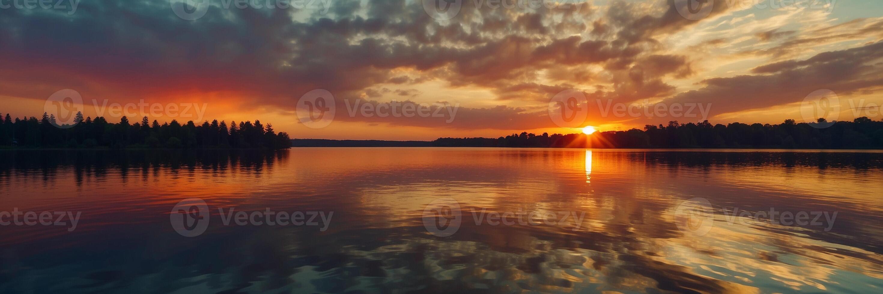 A beautiful sunset over a lake with trees photo
