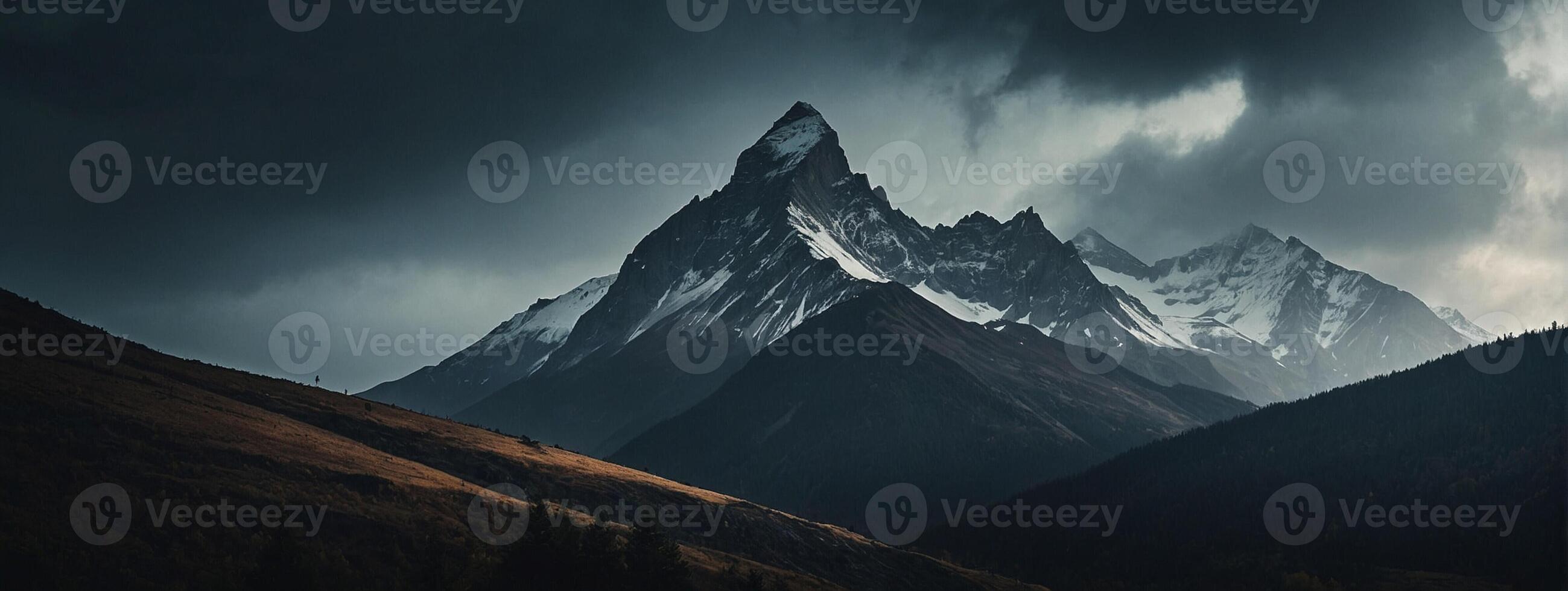A mountain range is shown under a dark sky photo