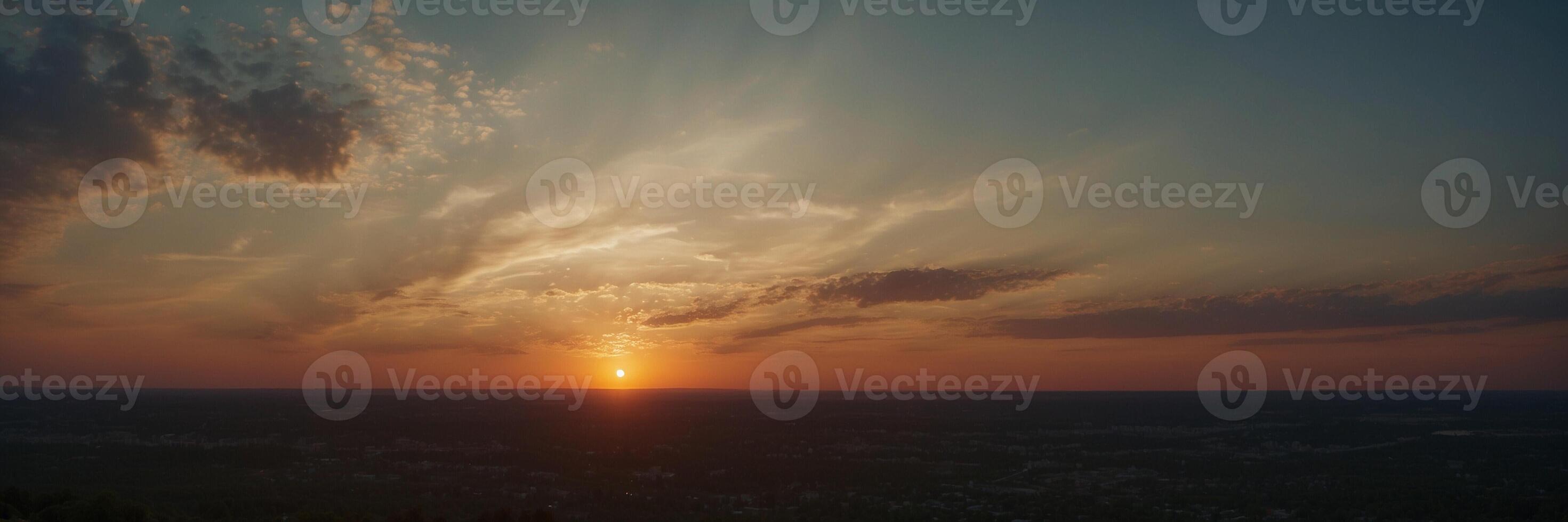 The sun sets over a city and the sky is cloudy photo