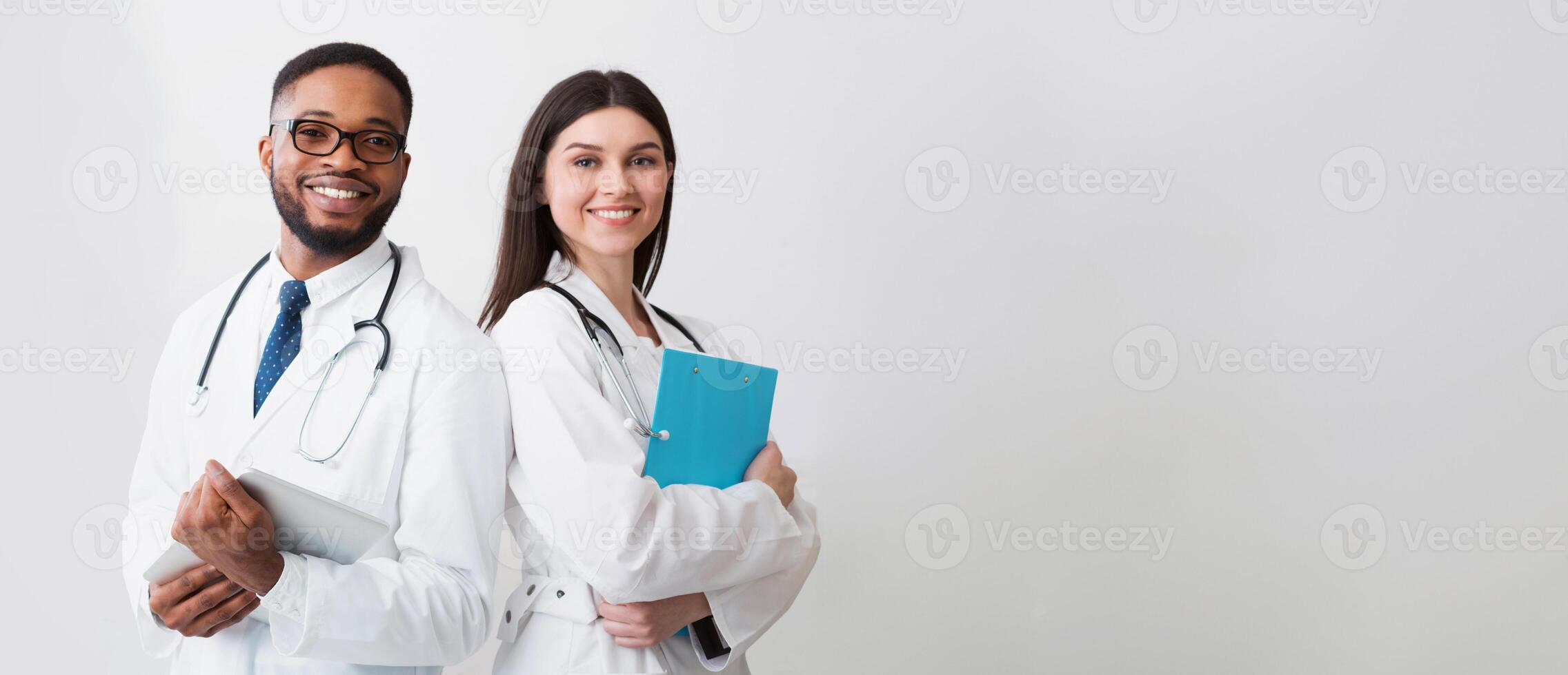 Happy Medic Workers. Portrait Of Two Doctors In White Coats Over White Background, Copy Space photo