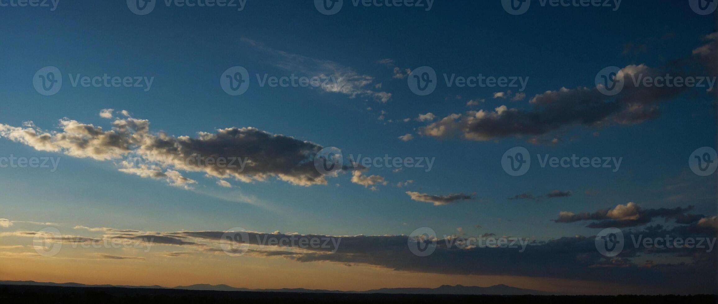 A sunset over the desert with clouds in the sky photo