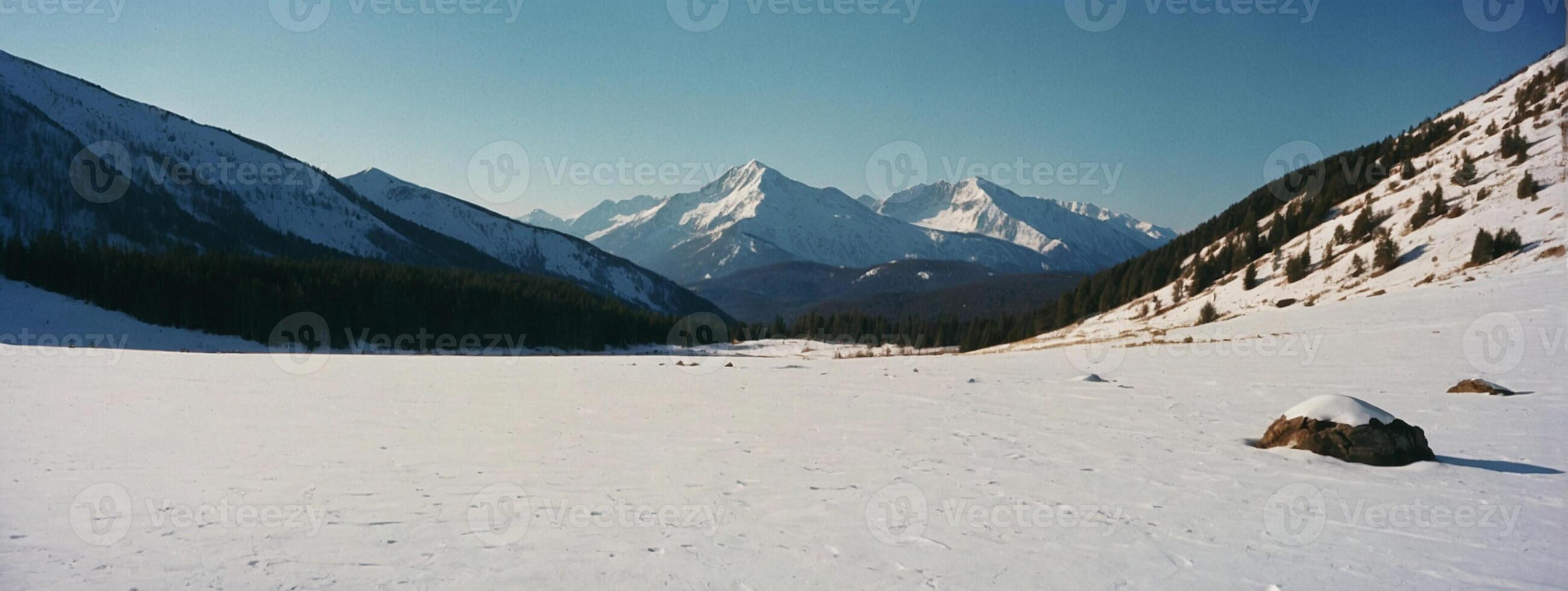 A snowy mountain range with a lake and rocks photo