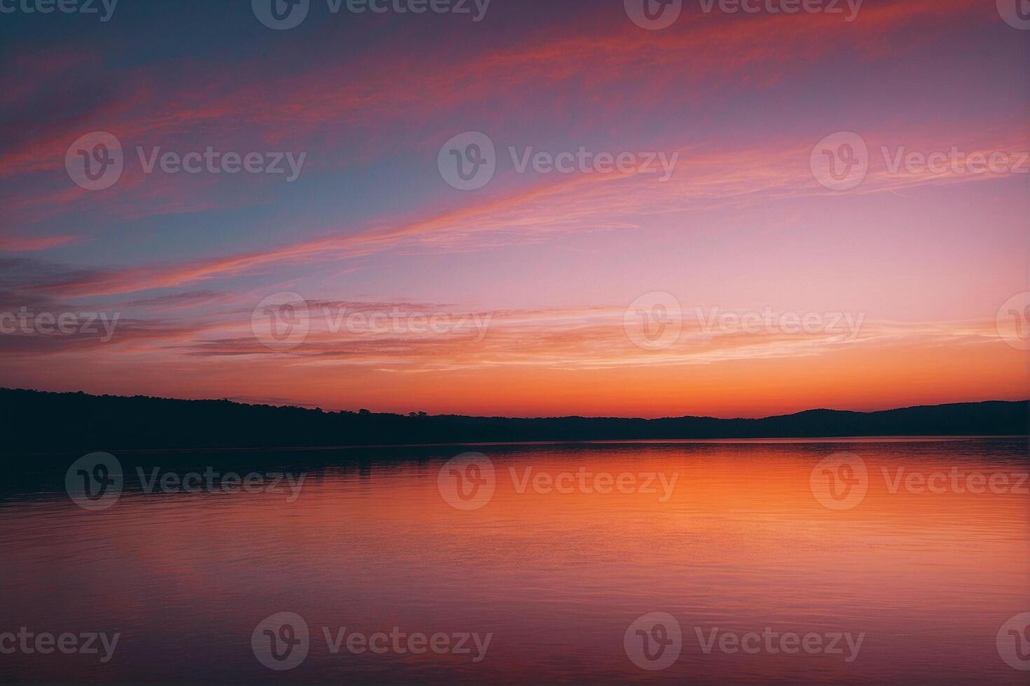 A sunset over a lake with a sky and clouds photo