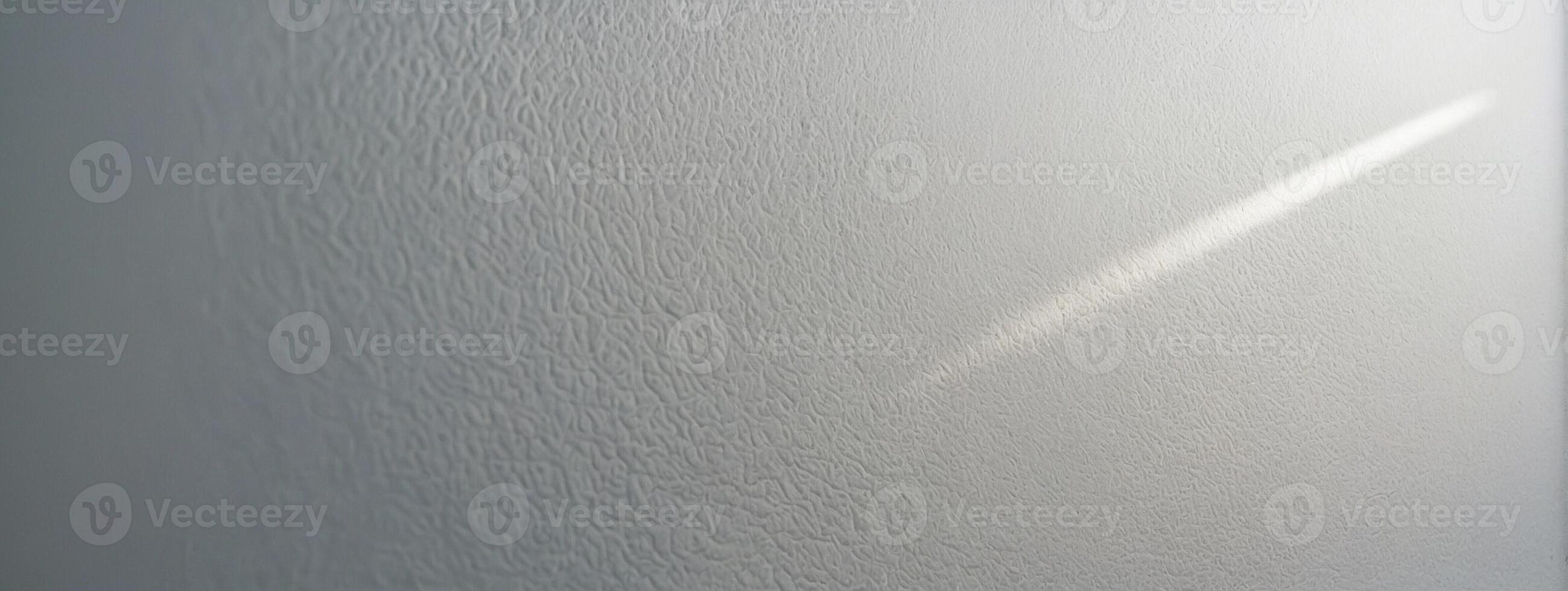 A white wall with a light shining on it photo