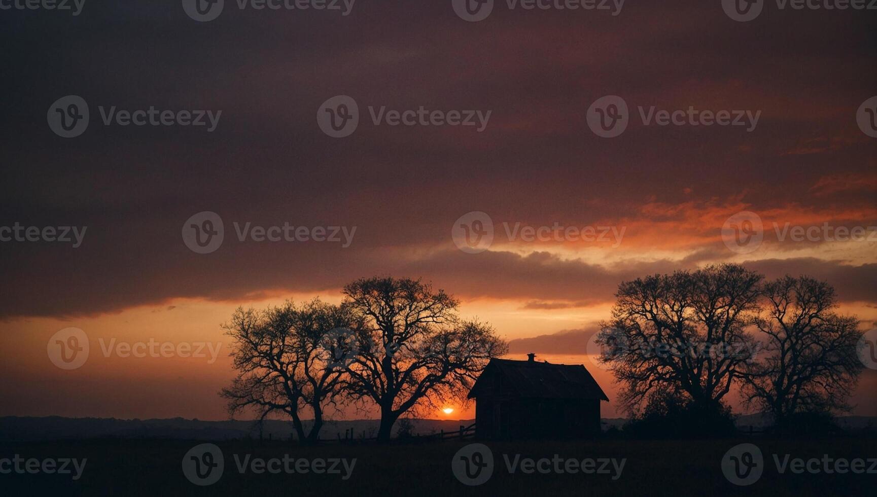 A house and trees are silhouetted against a sunset photo
