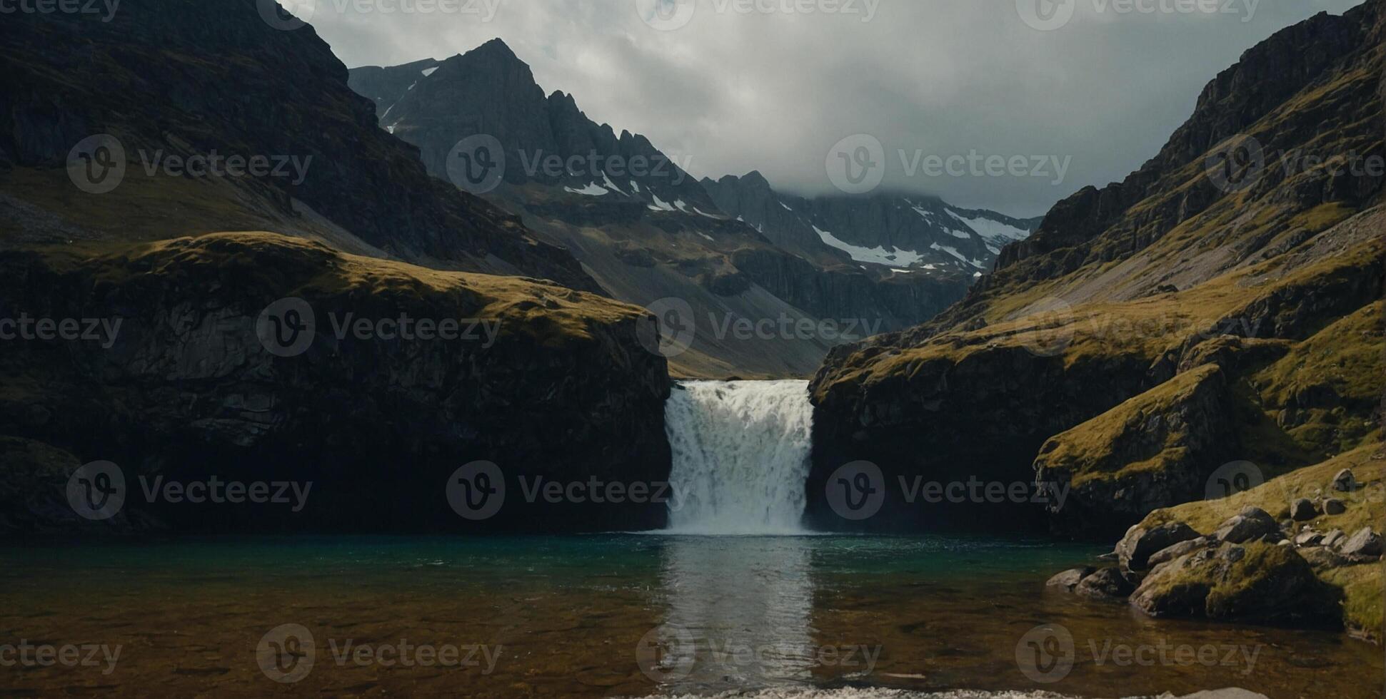 A waterfall in the middle of a mountain range photo