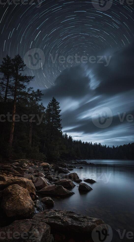 Star trails over the water and rocks photo