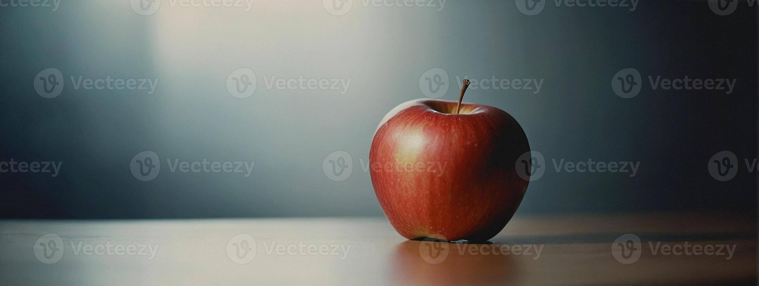 An apple sitting on a table in front of a blurry background photo