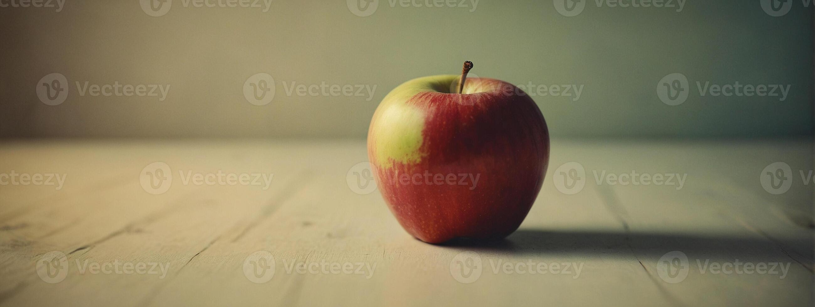 An apple sitting on a table with a blurry background photo