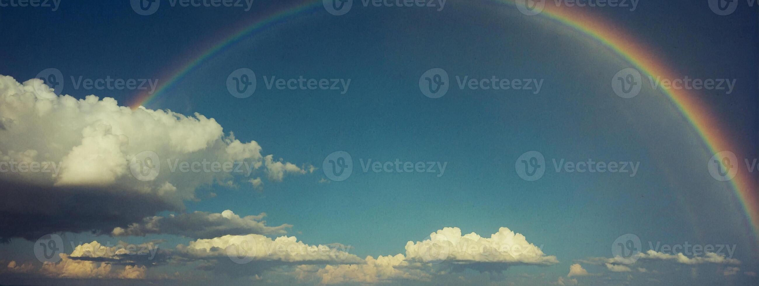 A rainbow is seen in the sky over a body of water photo