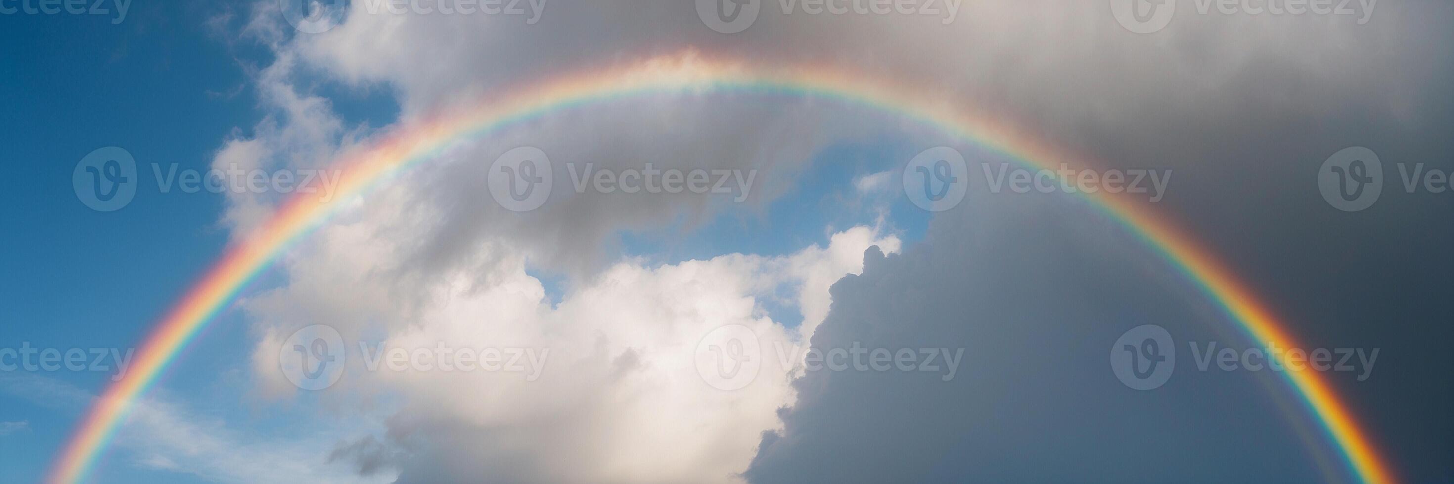 A rainbow is shown in the sky with clouds photo