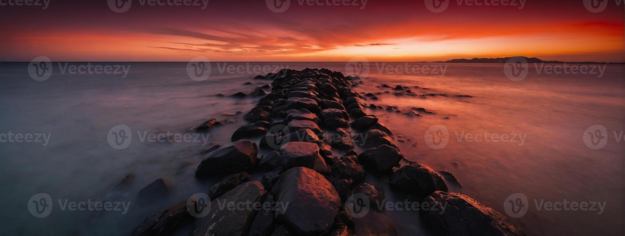 A long exposure photograph of rocks in the ocean photo