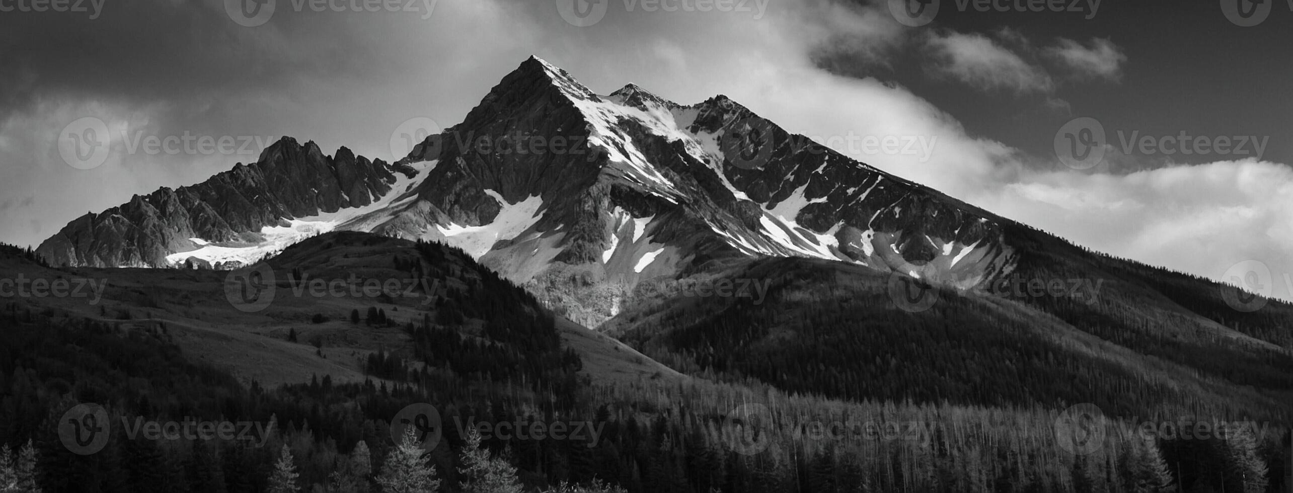 Black and white photograph of a mountain with trees and clouds photo