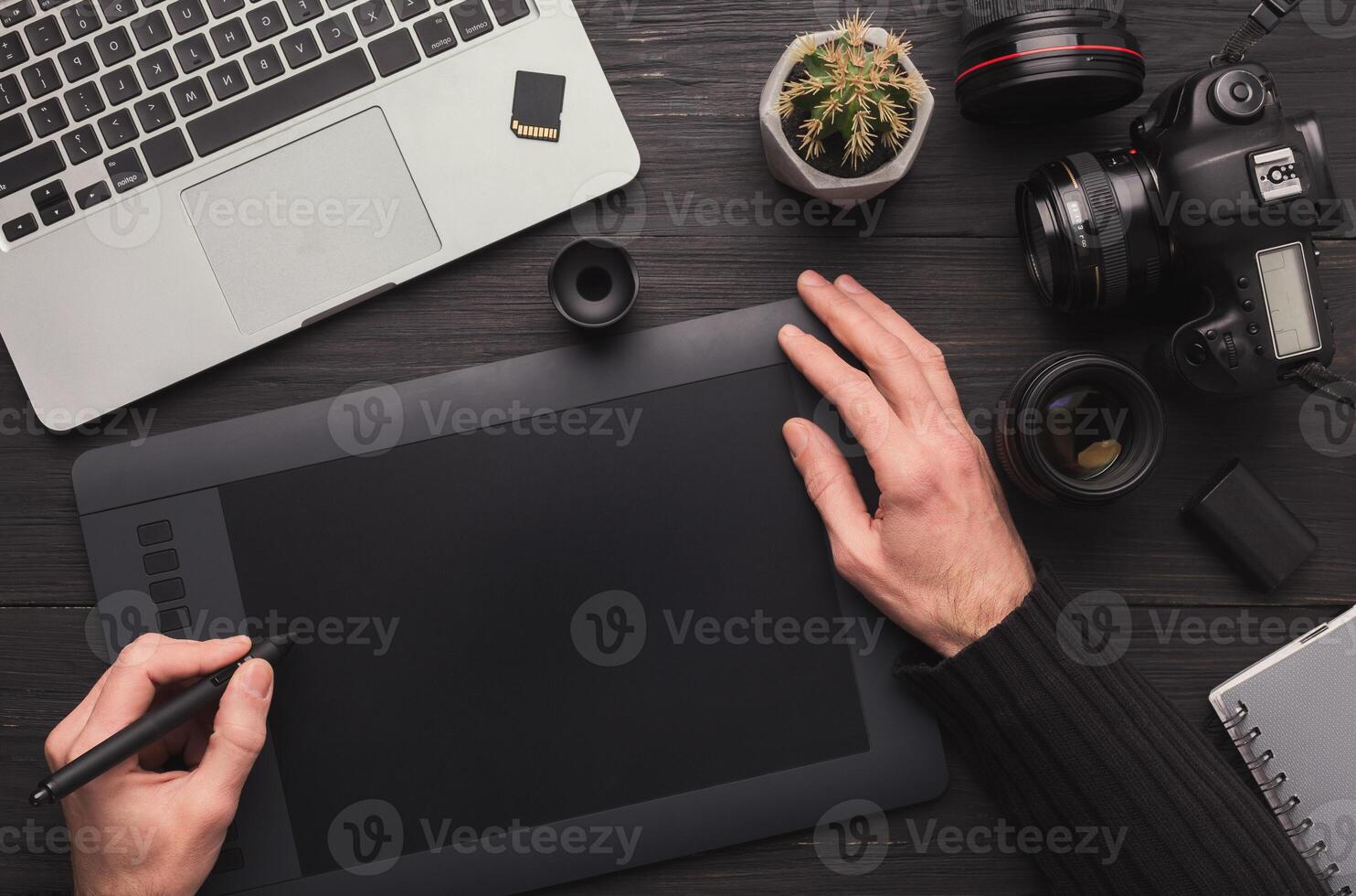 Top view on workplace of photographer. Creative designer hands working graphic tablet, photographic equipment on table photo