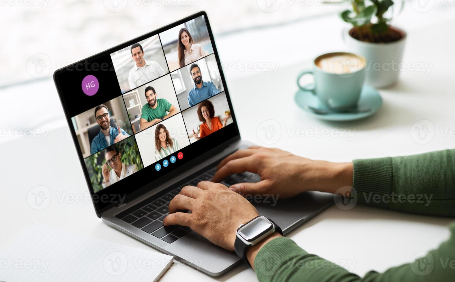 Freelancer is sitting at a desk in front of a laptop and participating in an online conference with multiple people, cafe interior photo