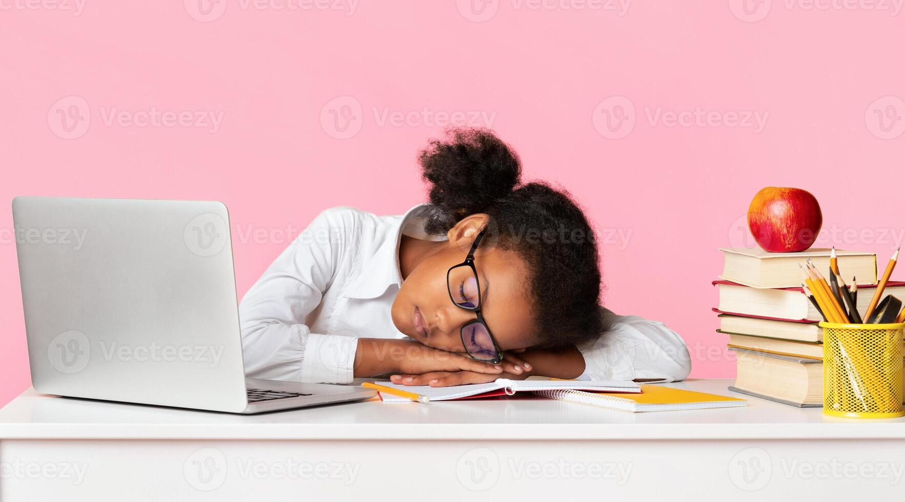 Exhausted Black Schoolgirl Sleeping At Laptop Computer Doing Homework On Yellow Background In Studio. School Overload Concept. Panorama photo