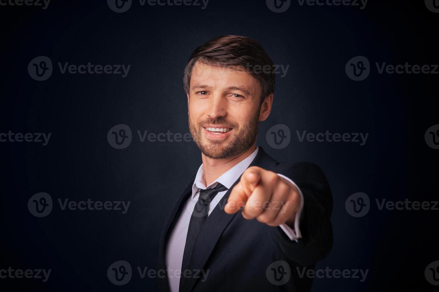 You're Next. Confident Businessman Pointing Finger Smiling At Camera Over Black Background. Studio Shot, Free Space photo