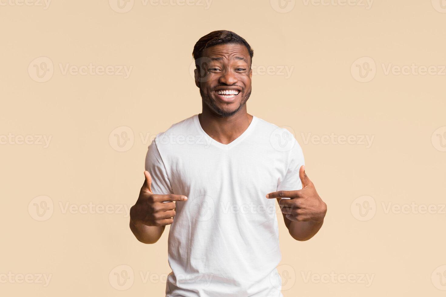Look At Me. Black Man Pointing Fingers At Himself Smiling At Camera Standing Over Yellow Studio Background photo