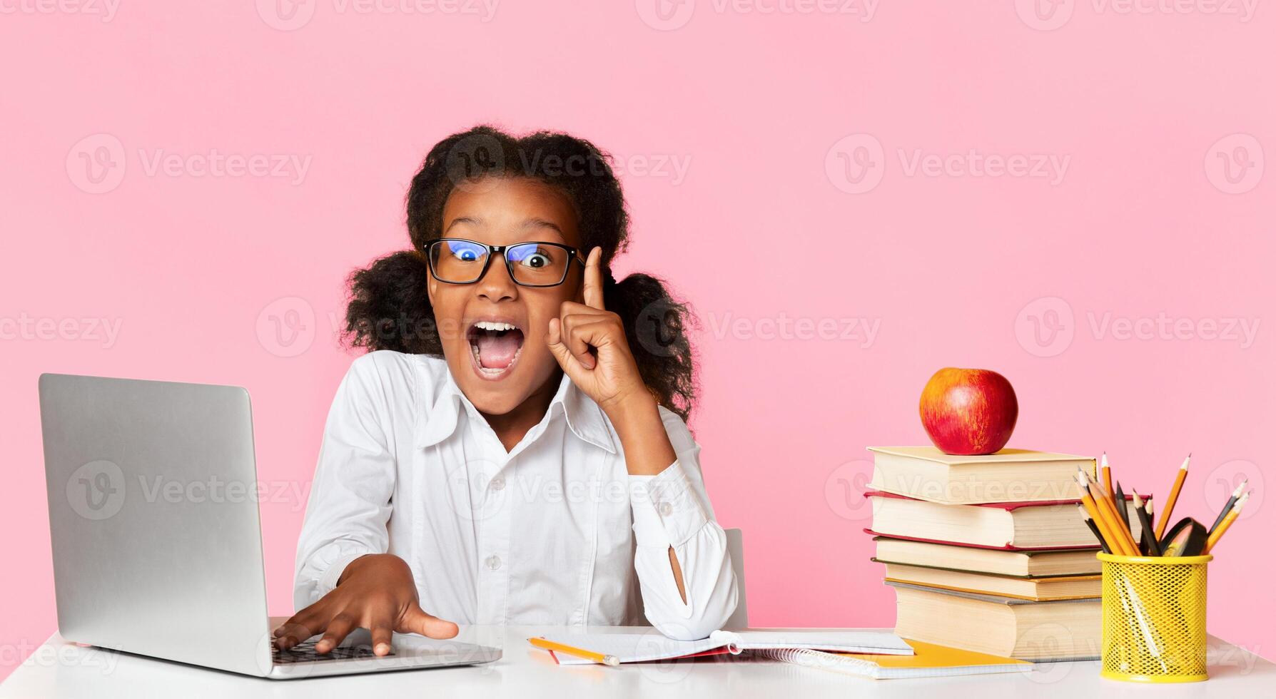 Online Learning. Excited School Girl At Laptop Pointing Finger Up Having Idea Sitting Over Yellow Background. Panorama photo