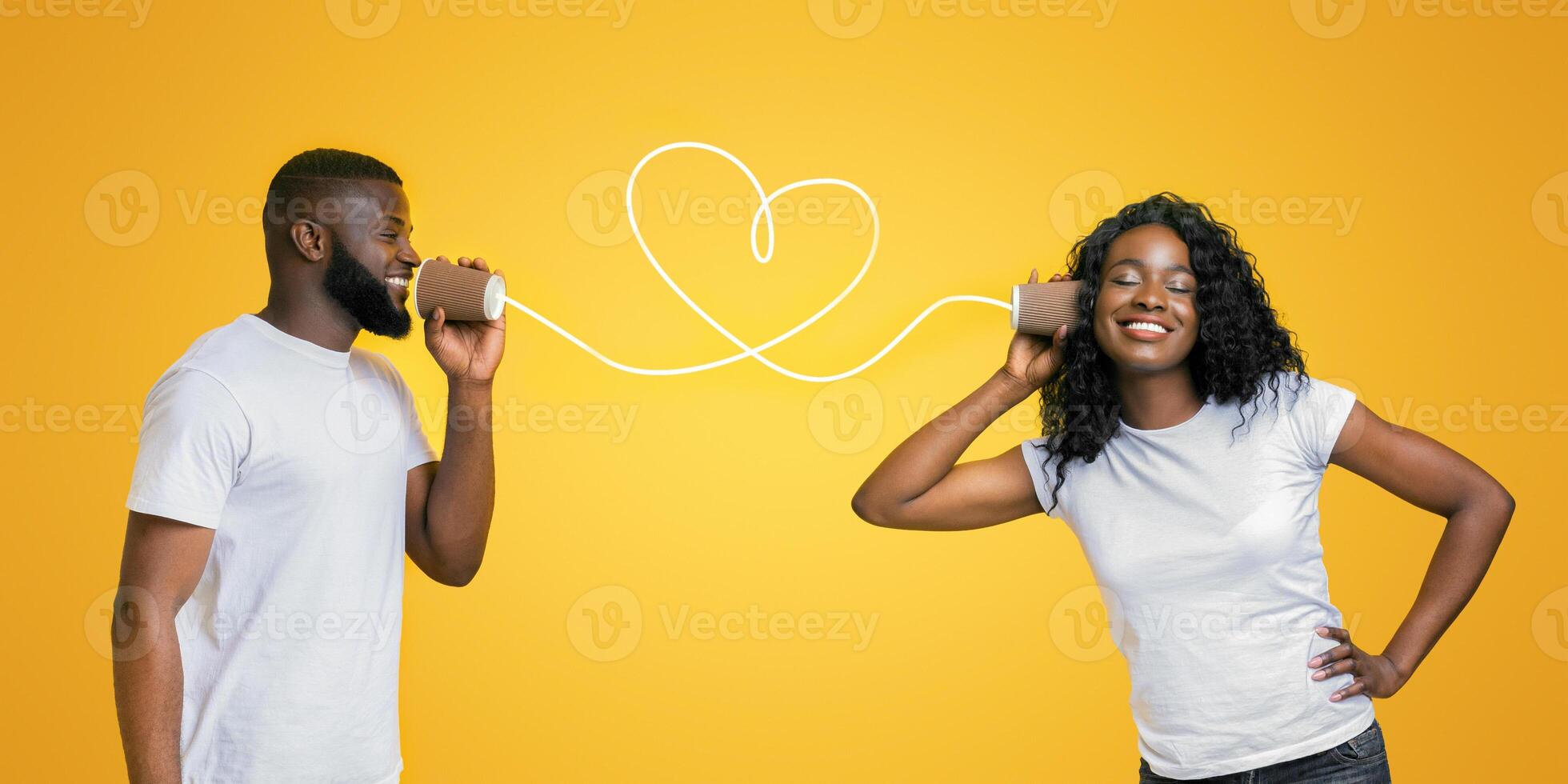 Communication and fun. Young black couple talking through tin can phone, yellow background photo