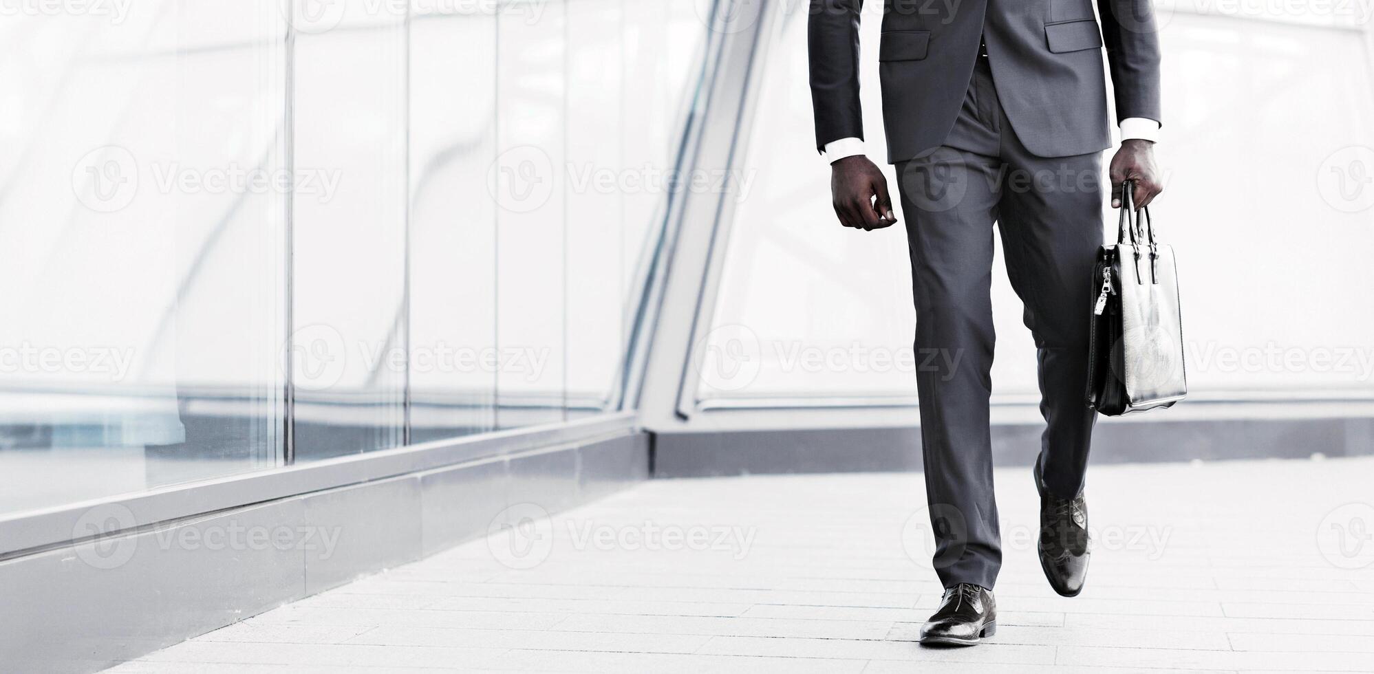 Successful Business Manager. Unrecognizable African American Guy Holding Briefcase Walking Against Modern Building. Cropped, Panorama With Copy Space photo