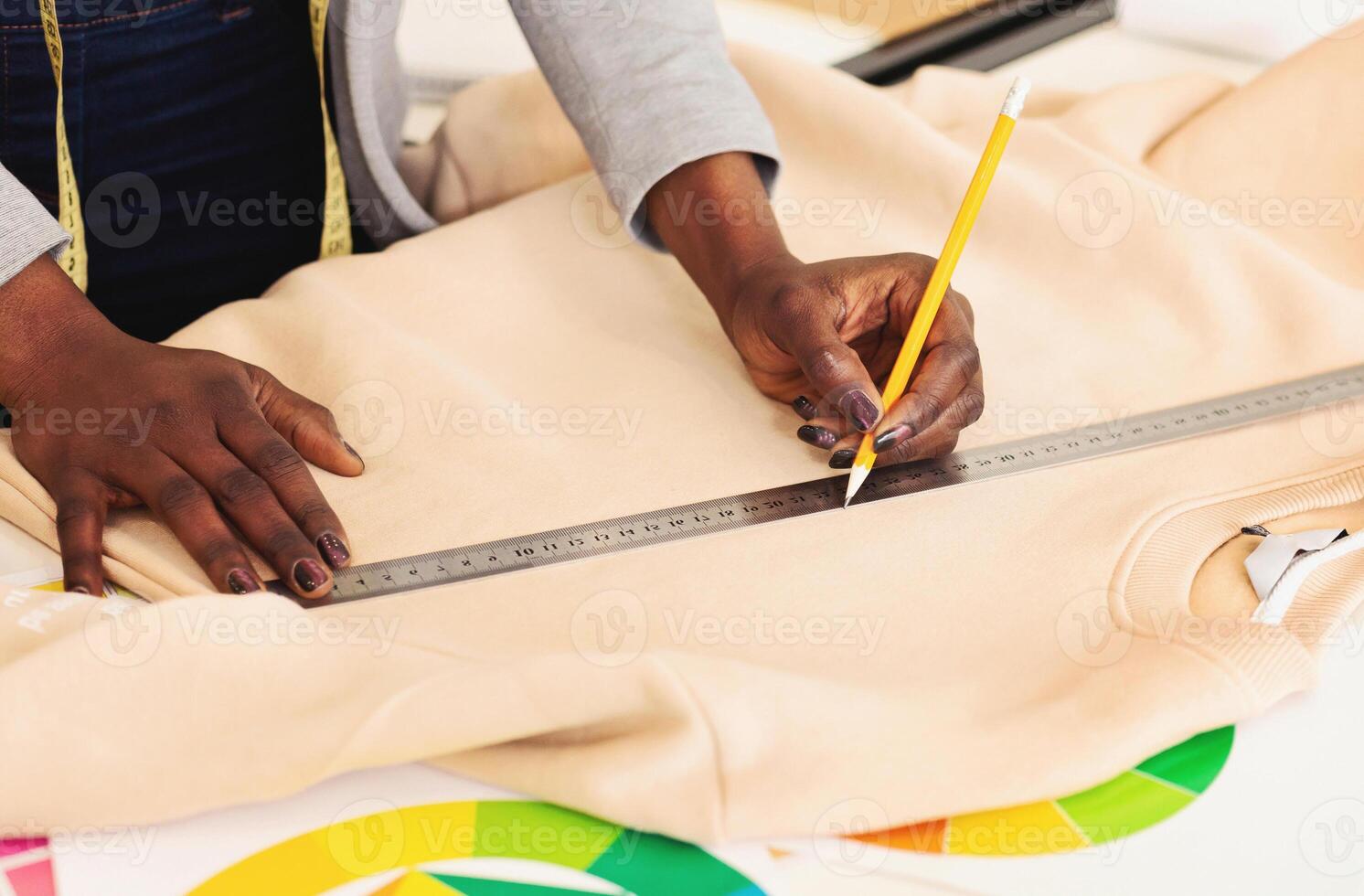A person is shown in the image measuring a piece of cloth using a ruler, focusing intently on accurately determining the length of the fabric, cropped photo