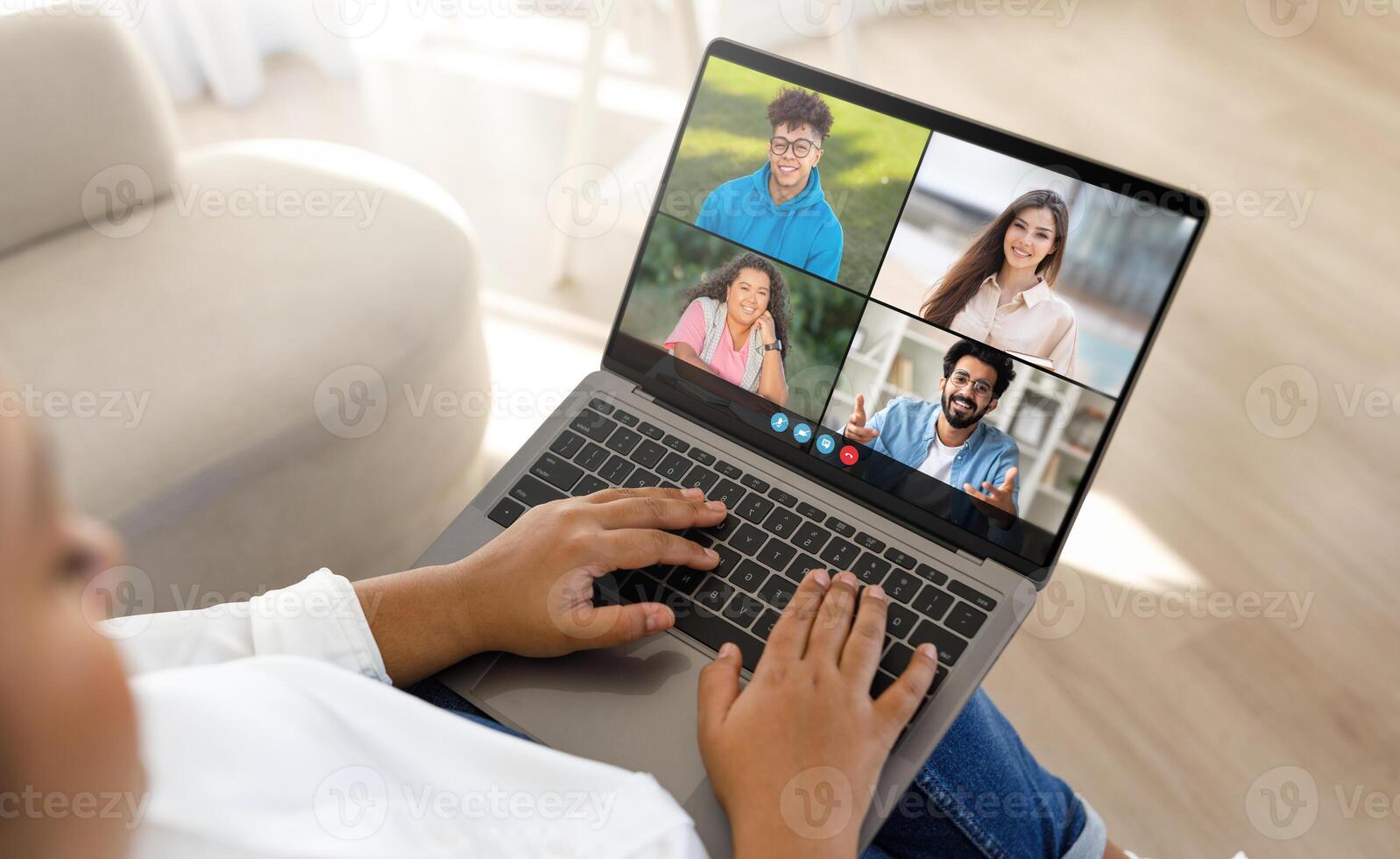 Black lady is engaged in a virtual meeting with four friends, visible on a laptop screen, in a bright and cozy room. Each participant is smiling, suggesting a joyful and interactive session. photo