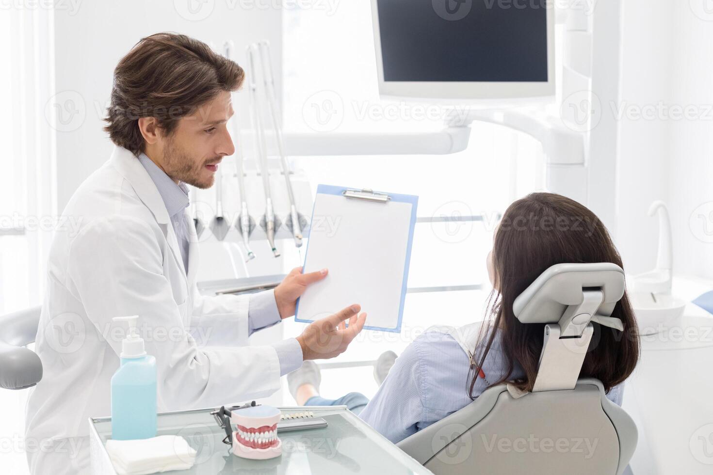 Dentist showing patient folder with blank empty paper to fill up survey, clients satisfaction concept photo