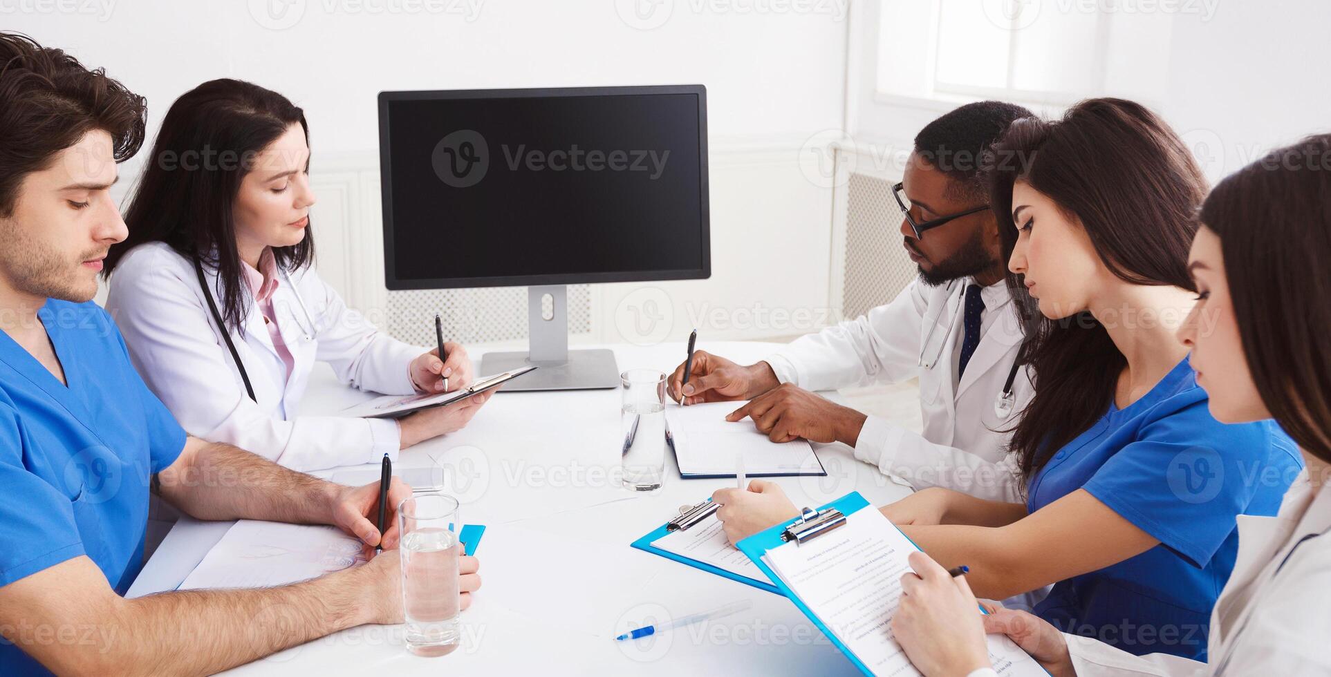 Online Education. Doctor And Interns Having Lecture And Taking Notes In Meeting Room photo