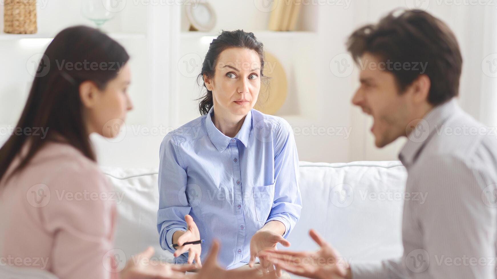 A young couple and a lady counselor engage in a meaningful therapy session, focusing on emotional growth and relationship healing in a welcoming setting. photo