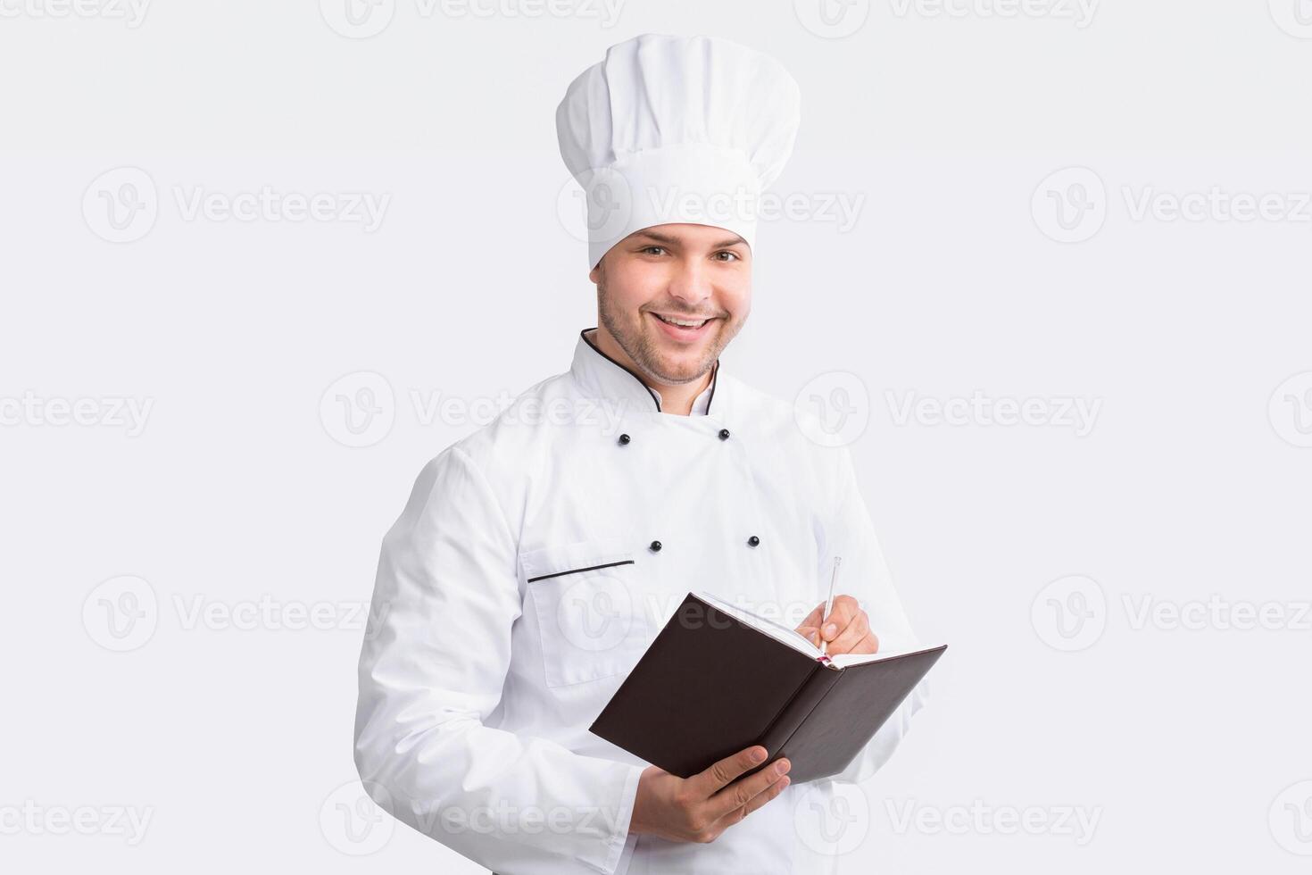 Chef Man Writing Recipes In Culinary Book Standing Over White Studio Background. Panorama photo