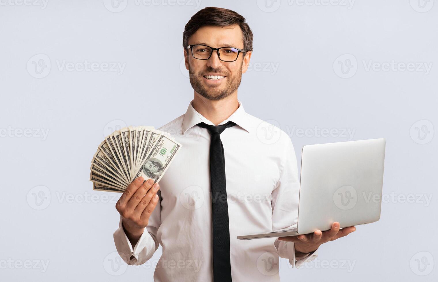 Online Job. Happy Businessman Holding Laptop And Cash Money On White Background In Studio. Isolated photo