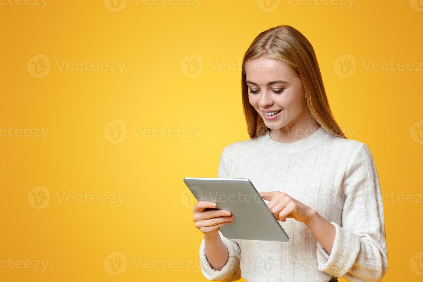 App For Students. Beautiful teen girl using digital tablet over orange studio background, panorama with copy space photo